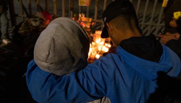 Una pareja presenta sus respetos durante una vigilia frente a las instalaciones de inmigración mexicanas donde al menos 38 migrantes murieron en un incendio, en Ciudad Juárez, estado de Chihuahua, el 28 de marzo de 2023, México. (Foto por Guillermo Arias / AFP)