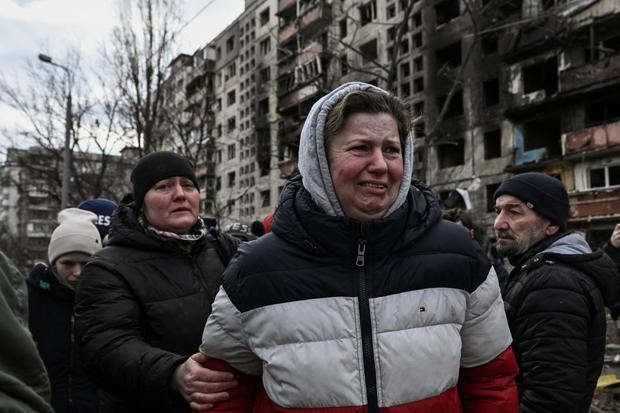 A woman cries in front of the destroyed apartment blocks.  (ARIS MESSINIS / AFP).