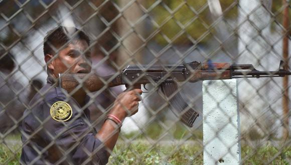 Un oficial del sistema penitenciario toma posición frente a la prisión de máxima seguridad de Pavón en el municipio de Fraijanes, Guatemala, el 7 de mayo de 2019, durante un motín. (Foto de JOHAN ORDONEZ / AFP).