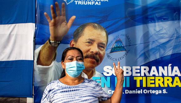 Una mujer hace un gesto frente a una pancarta que promueve la candidatura del presidente de Nicaragua, Daniel Ortega, en Managua el 24 de septiembre de 2021. (OSWALDO RIVAS / AFP).