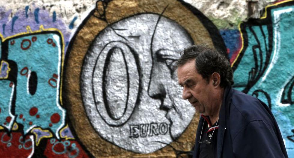 Mujer frente a imagen de moneda de cero euros en Atenas. (Foto:EFE)