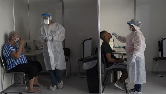 A las personas se les toman hisopos nasales para las pruebas de COVID-19 en la favela Mare Complex de Río de Janeiro, Brasil. (Foto Referencial: AP/ Silvia Izquierdo).