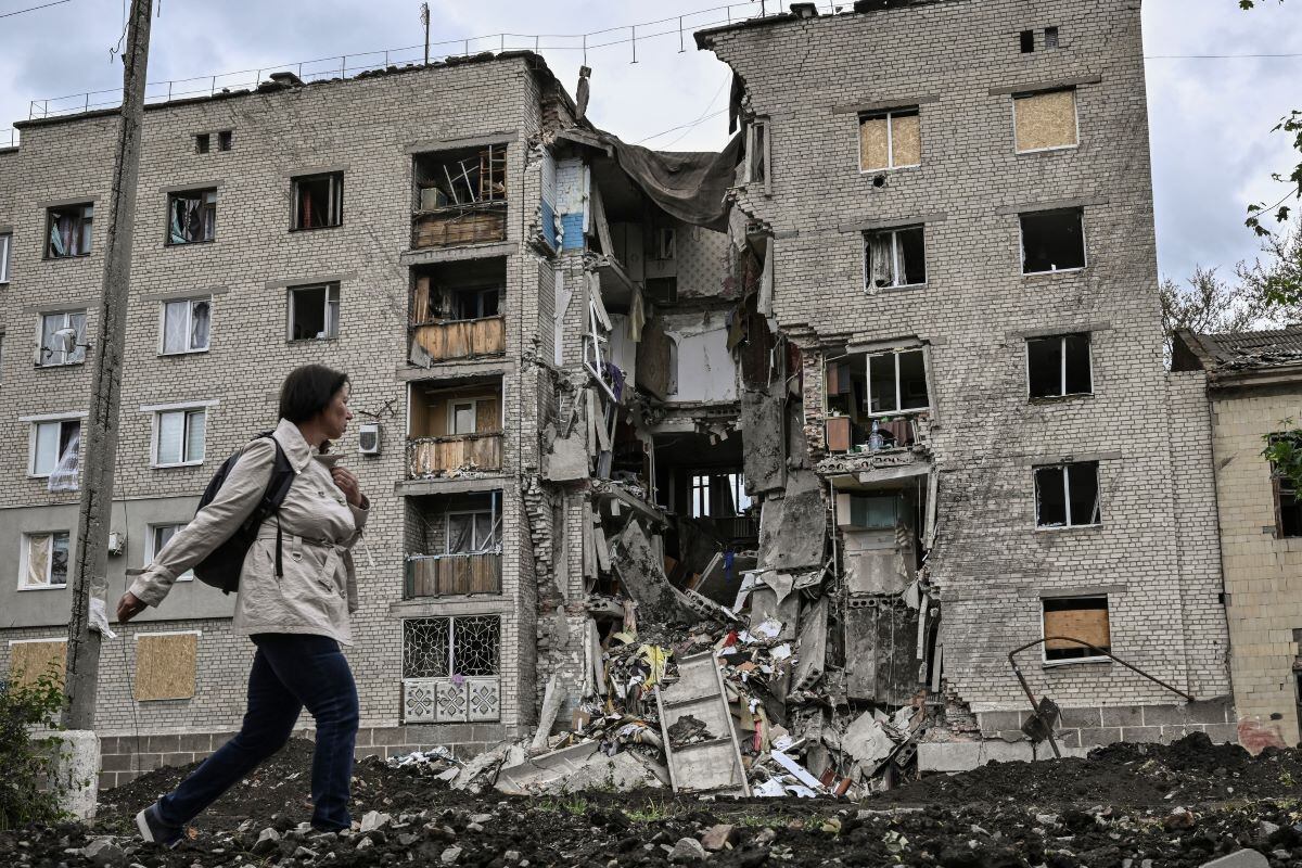 A woman walks past a destroyed apartment building in Bakhmut, in Ukraine's eastern Donbas region, on May 22, 2022. (ARIS MESINIS / AFP)