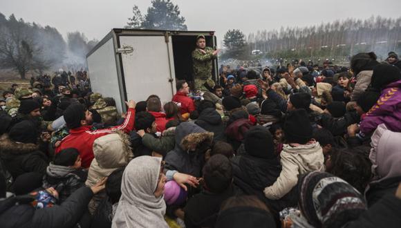 Migrantes se reúnen para obtener ayuda humanitaria difundida por militares bielorrusos en el campamento en la frontera entre Bielorrusia y Polonia en la región de Grodno, no lejos del puesto de control de Bruzgi, Bielorrusia. (Foto: EFE / EPA / STR).