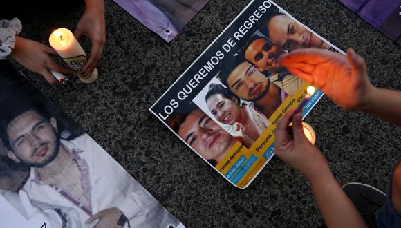Familiares de ocho personas desaparecidas encienden velas junto a sus fotografías durante una manifestación en Guadalajara, México. (Foto por ULISES RUIZ / AFP)