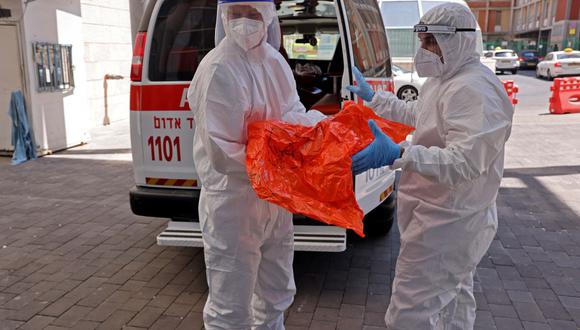 Personal médico del Magen David Adom transfieren las pertenencias de un paciente con coronavirus al Hospital Hadassah Ein Kerem en Jerusalén, Israel, el 15 de agosto de 2021. (Menahem KAHANA / AFP).