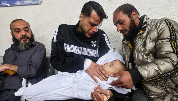 El padre palestino Ashraf sostiene a una de sus dos hijas después de que ambas murieran en un ataque aéreo israelí nocturno, el 4 de abril de 2024 en el hospital al-Najar en Rafah, en el sur de la Franja de Gaza. (Foto de MOHAMMED ABED / AFP)