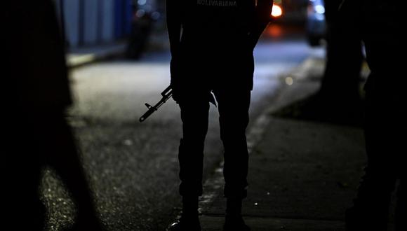 Un miembro de la Guardia Nacional Bolivariana monta guardia en la calle principal de acceso al diario venezolano El Nacional mientras miembros de un tribunal llevan a cabo un embargo judicial. (YURI CORTEZ / AFP).