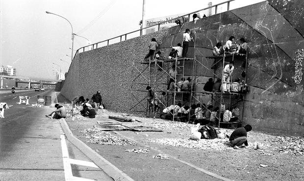 LIMA, JUNE 26, 1992 A GROUP OF YOUNG PEOPLE FROM CEDRO WORKS ON A 500-METRE MURAL ON A WALL OF THE EXPRESSWAY, BETWEEN THE RICARDO PALMA AND BENAVIDES BRIDGES, IN MIRAFLORES.  THIS DESIGN WAS CREATED BY RICARDO WIESSE.  PHOTO: THE TRADE  