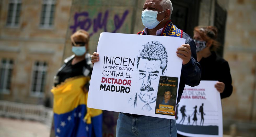 Aprovechando la visita del fiscal de la Corte Penal Internacional a varias partes de Latinoamérica, personas salen a marchar a las calles para pedir justicia. En esta imagen, un individuo sostiene un cartel para denunciar a Maduro como dictador. Imagen tomada en Bogotá. REUTERS