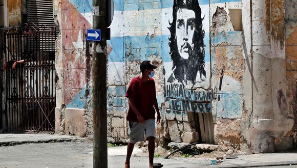 Un hombre camina frente a un mural de Ernesto Che Guevara en La Habana, Cuba. La Isla se mantiene en una tensa calma con presencia policial en las calles, cuatro días después de que masivas protestas antigubernamentales sacudieran el país. (EFE/ Ernesto Mastrascusa).
