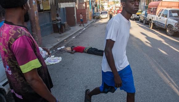 Un hombre pasa frente a un cadáver en una calle de Puerto Príncipe, Haití, el 3 de marzo de 2024. (Foto de Johnson Sabin / EFE)