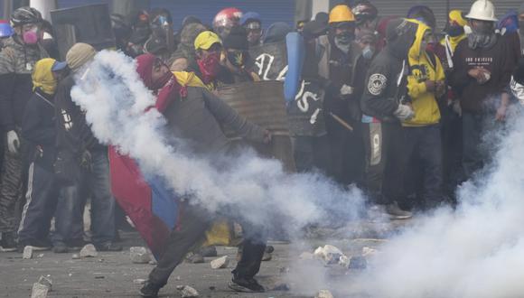 Un manifestante arroja un bote de gas lacrimógeno a la policía durante las protestas contra las políticas económicas del presidente Guillermo Lasso y exigiendo una reducción del precio del combustible, en el centro de Quito, Ecuador.