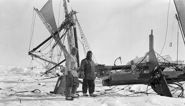 Shackleton (right) looks at the remains of his ship just before it sank to the depths.
