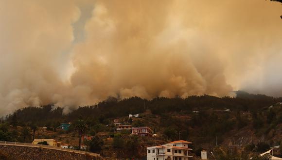Una fotografía tomada el 15 de julio de 2023 en la isla canaria española de La Palma muestra la ciudad evacuada de Tijarafe rodeada de humo que sale de un incendio forestal cerca del Parque Nacional La Caldera de Taburiente. (Foto: STRINGER / AFP)