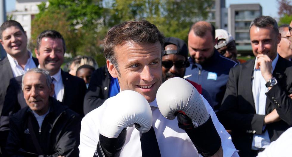 El presidente de Francia, Emmanuel Macron, usa guantes de boxeo cuando se encuentra con un boxeador local en el estadio Auguste Delaune el 21 de abril de 2022. (François Mori / AFP).