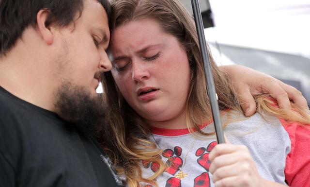 Anthony Moore y Kaitlyn Mitchell se abrazan durante un servicio público de oración por las víctimas del tiroteo en Virginia Beach que dejó 12 muertos. (AFP).
