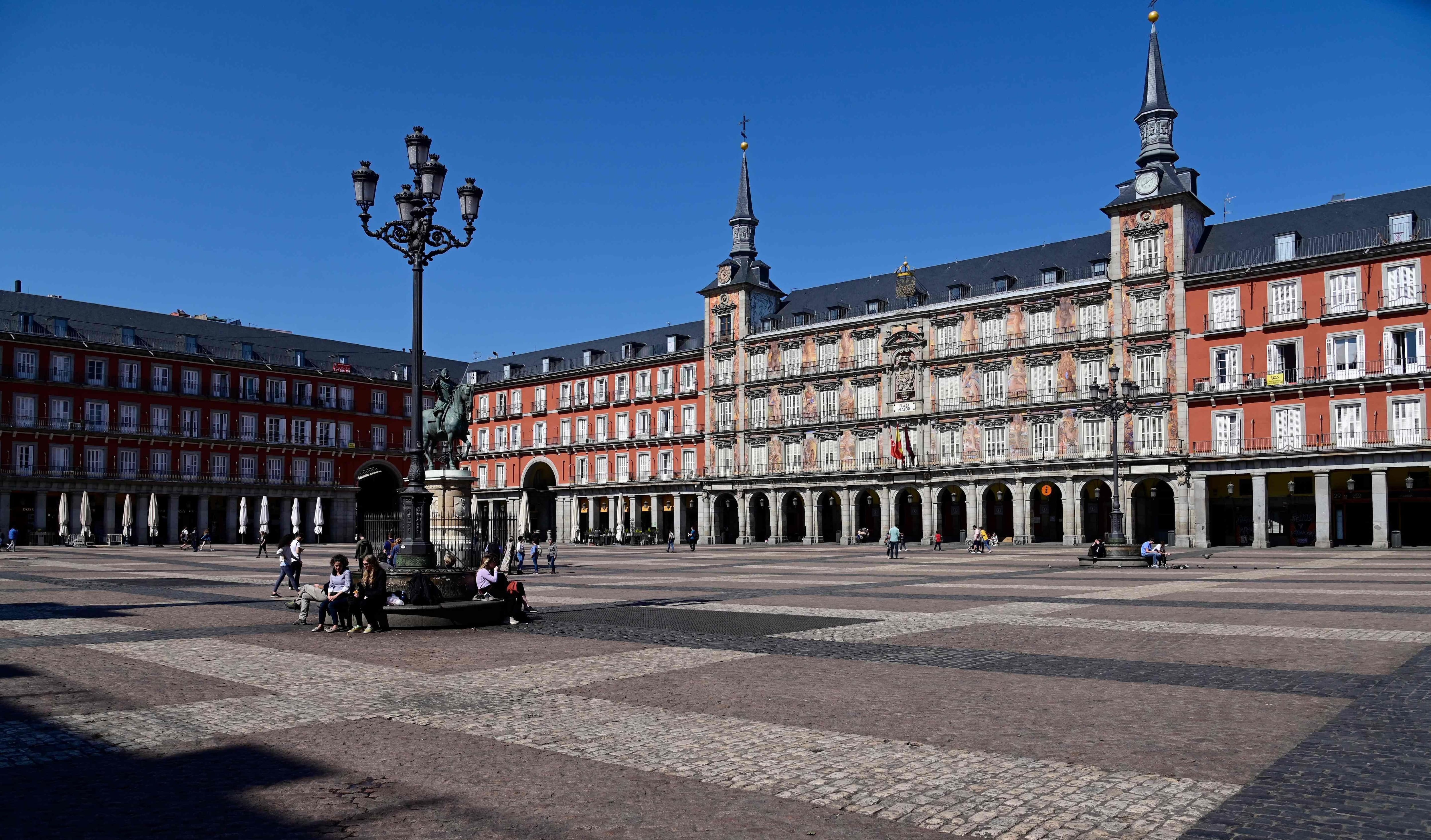 Pocas personas caminan en la Plaza Mayor de Madrid, generalmente abarrotada.Las autoridades regionales ordenaron cerrar todas las tiendas desde hoy hasta el 26 de marzo, a excepción de los que venden alimentos, químicos y estaciones de servicio, para frenar propagación del coronavirus. (AFP / JAVIER SORIANO).