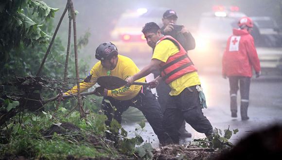 Rescatistas despejan el camino de acceso al lugar donde cinco militares murieron por un deslizamiento de tierra, tras el paso de la tormenta tropical Julia, en Comasagua, El Salvador.