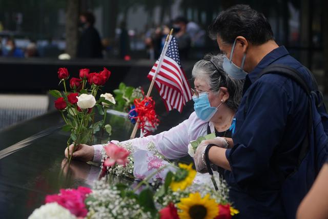 Las personas en Nueva York colocan flores en los nombres de las víctimas al borde de la piscina sur durante las ceremonias del 19° aniversario de los ataques del 11 de septiembre de 2001. (REUTERS/Carlo Allegri).