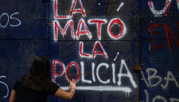 Una manifestante hace un grafiti que dice "La policía la mató"' durante una protesta en la Ciudad de México el 29 de marzo de 2021, por la muerte de la migrante salvadoreña Victoria Esperanza Salazar. (Foto de PEDRO PARDO / AFP).