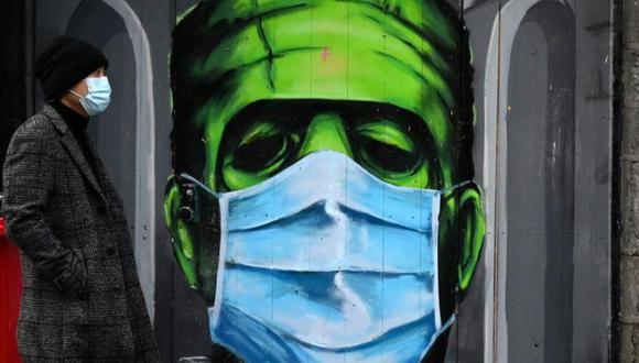 Un hombre pasa por delante de un graffiti de un Frankenstein que lleva una mascarilla durante la propagación de la pandemia de la enfermedad coronavirus (COVID-19), en Galway, Irlanda. (Foto: REUTERS/Clodagh Kilcoyne).