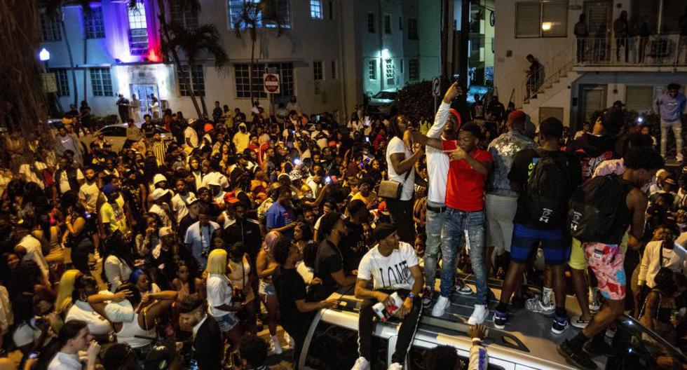Esta imagen del domingo muestra a una multitud desafiante en la calle mientras un altavoz emite música una hora después del toque de queda en Miami Beach, Florida. Las autoridades han endurecido las medidas en medio de la pandemia del coronavirus COVID-19. (Foto: Daniel A. Varela / Miami Herald vía AP)