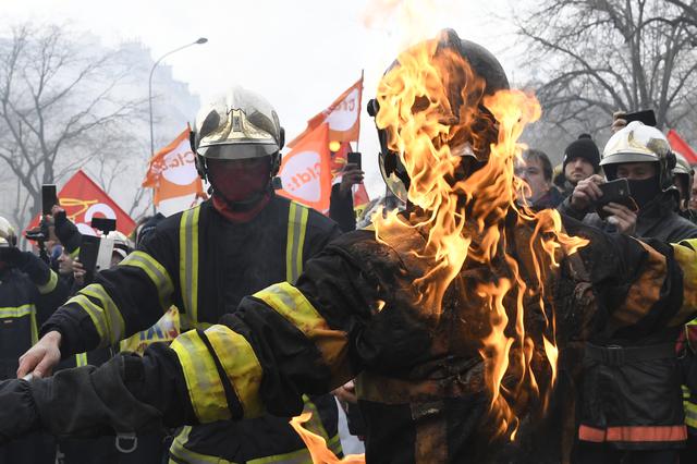 Un bombero enciende a otro durante la manifestación contra el plan de gobierno francés para revisar el sistema de jubilación del país. (Foto: AFP)