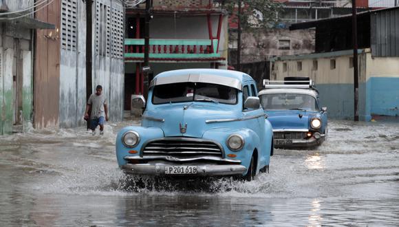Un auto clásico pasa por una calle llena de agua, hoy en La Habana (Cuba).