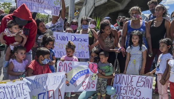Los migrantes venezolanos que desean regresar a su país debido a la nueva pandemia de coronavirus, sostienen carteles durante una protesta frente a la terminal de autobuses en Medellín, Colombia, en demanda de la oportunidad de subir a un autobús para llevarlos a la frontera. (Foto de JOAQUIN SARMIENTO / AFP).