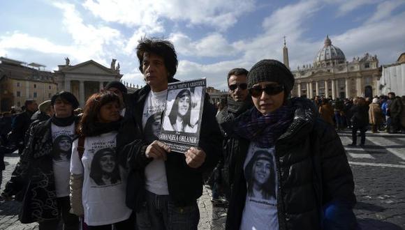 Familiares sostienen carteles de Emanuela Orlandi donde se lee "Desaparecidos" durante la oración de Regina Coeli del Papa Benedicto XVI en la plaza de San Pedro, en 2012. (Foto: AFP)