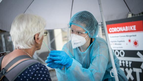 A woman is being tested for the the coronavirus / COVID-19  at a mobile test station in Berlin's Kreuzberg district on July 30, 2021, amid the ongoing coronavirus / COVID-19 pandemic. (Photo by STEFANIE LOOS / AFP)