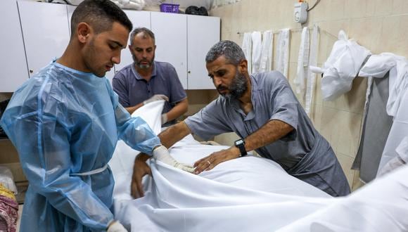 Médicos envuelven el cuerpo de un palestino muerto en un ataque israelí en el hospital Najjar en Rafah, en el sur de la Franja de Gaza, el 24 de octubre de 2023, en medio de las batallas en curso entre Israel y el grupo palestino Hamás. (Foto de Mohammed ABED / AFP)