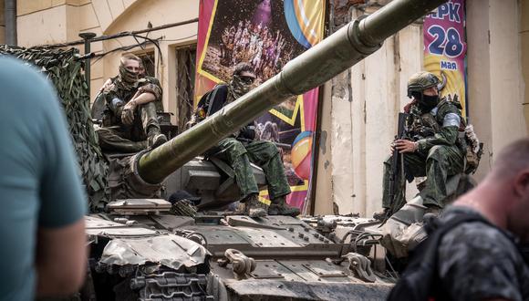 Los miembros del grupo Wagner se sientan encima de un tanque en una calle de la ciudad de Rostov-on-Don. (Foto de Roman ROMOKHOV / AFP)