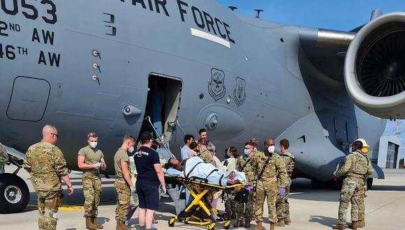 En esta imagen de la Fuerza Aérea de Estados Unidos, el personal de apoyo médico ayuda a una madre afgana y su familia a bajar de un C-17 momentos después de que ella diera a luz a un niño a bordo del avión. (US AIR FORCE / AFP).