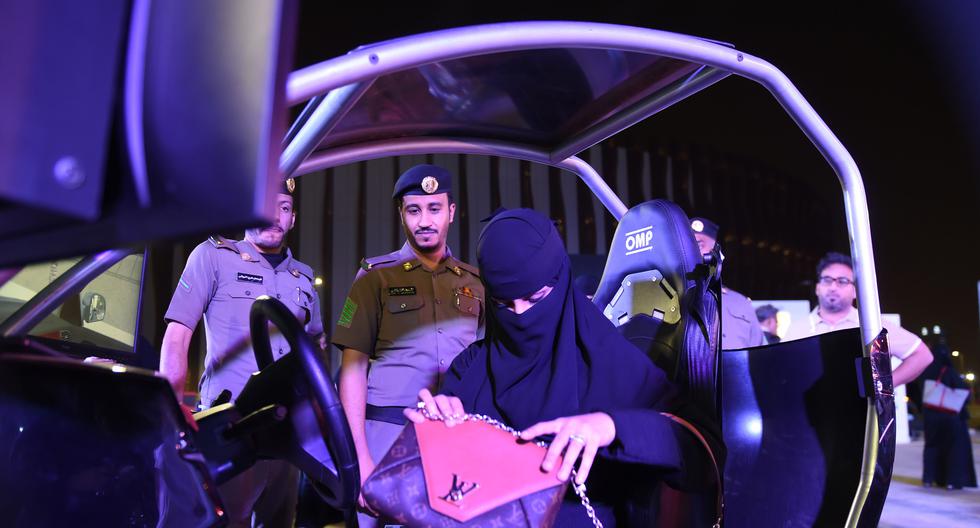 La policía de Arabia Saudita observa a una mujer que está en un simulador de conducción de autos. (Foto referencial, FAYEZ NURELDINE / AFP).