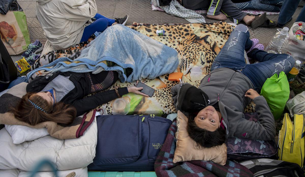 Los ciudadanos venezolanos varados permanecen fuera del consulado de Venezuela en Santiago, mientras esperan una solución después de que se cerraron las fronteras debido a la nueva pandemia de coronavirus. (Foto: AFP/Martin BERNETTI)