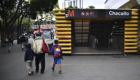 Peatones pasan por una estación de metro cerrada durante un apagón en Caracas el 26 de marzo de 2019. (Yuri CORTEZ / AFP).