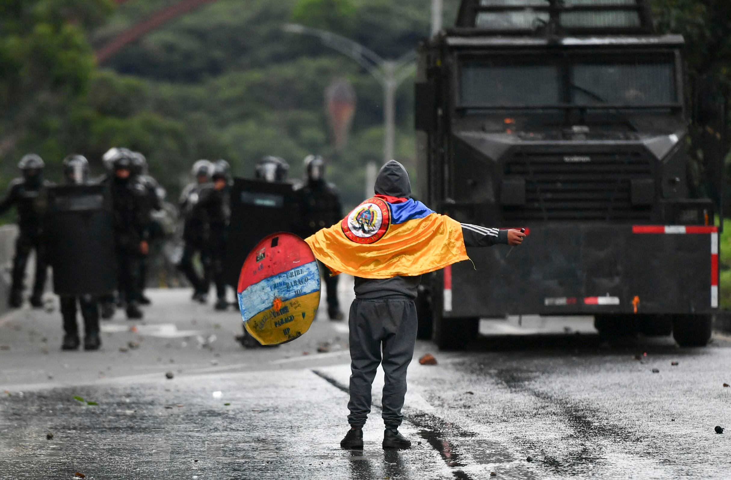 A demonstrator confronts riot police during a protest against the government of Colombian President Iván Duque to commemorate the first anniversary of a social outbreak, in Medellin, Colombia, on April 28, 2022.