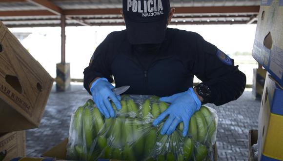 Un miembro de la Unidad de Información Portuaria de la Policía Antinarcóticos revisa cajas de banano con destino a Italia en el puerto de Guayaquil, Ecuador el 12 de abril de 2022. (Foto: Marcos Pin / AFP)