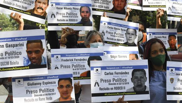 Manifestantes convocados por la ONG Foro Penal Venezolano portan retratos de presos políticos arrestados por el régimen chavista durante una protesta en diciembre del 2020. Según la organización, 10 detenidos por causas políticas han muerto en los últimos 7 años en el país. (Foto: Yuri Cortez / AFP)