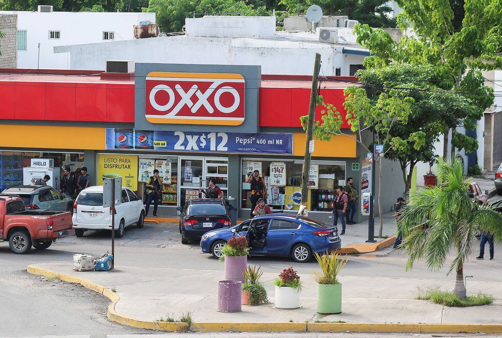 Civiles armados, presuntos miembros del cártel de Sinaloa, fuera de un Oxxo ubicado en Culiacán, ciudad donde desataron feroces enfrentamientos con las autoridades tras la captura de Ovidio Guzmán. (Reuters)
