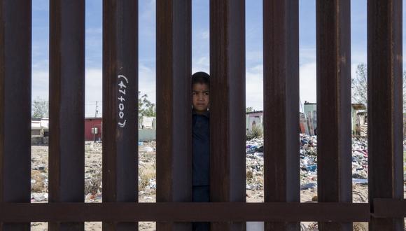 Imagen de archivo | Se muestra a un niño mexicano mirando desde el lado mexicano de la valla fronteriza en Anapra, cerca de El Paso, Texas, el sábado 7 de abril de 2018.