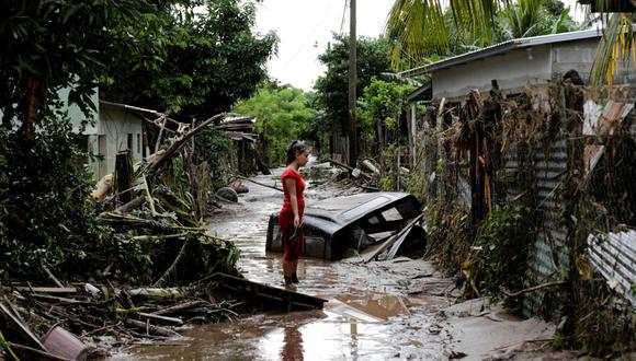Una mujer se encuentra fuera de su casa dañada por las fuertes lluvias provocadas por el huracán Eta, en Pimienta, Honduras, el 6 de noviembre de 2020. (REUTERS/Jorge Cabrera).