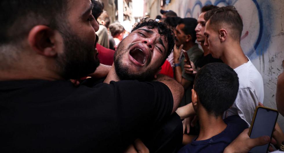 El amigo de un joven palestino asesinado durante la noche en el campo de refugiados de Jabalia, en el norte de la Franja de Gaza, llora durante su funeral, el 7 de agosto de 2022. (MAHMUD HAMS / AFP).