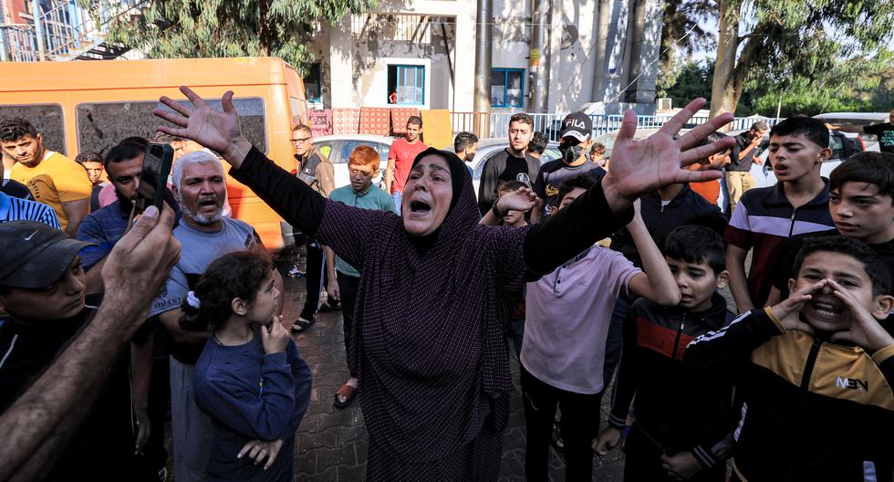 Una mujer reacciona mientras la gente se reúne en el sitio del hospital Ahli Arab en el centro de Gaza el 18 de octubre de 2023, luego de un ataque nocturno que dejó cientos de muertos. (Foto de AFP).