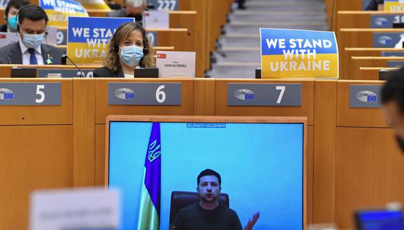 El presidente de Ucrania, Volodymyr Zelensky, aparece en una pantalla mientras habla en una videoconferencia durante una sesión plenaria especial del Parlamento Europeo. (JOHN THYS / AFP).
