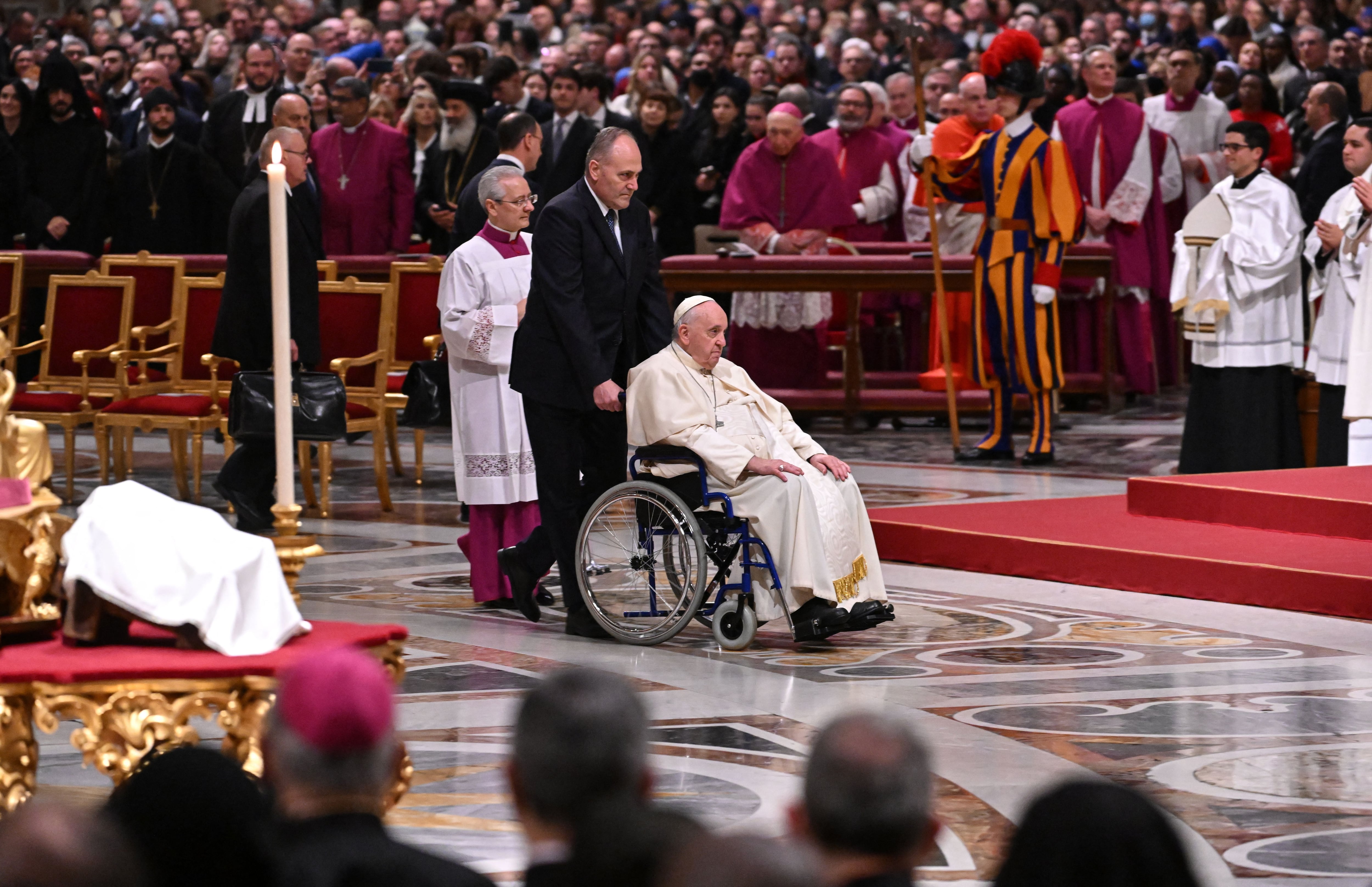 Pope Francis (C) arrives for Christmas Eve mass at St. Peter's Basilica in the Vatican on December 24, 2022.