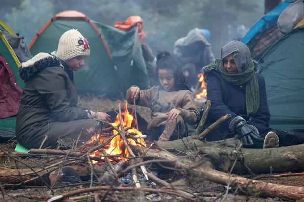 Imigranci osiedlili się w namiotach w pobliżu granicy z drutu kolczastego, płonąc ogniem.  (Zdjęcie: Reuters)