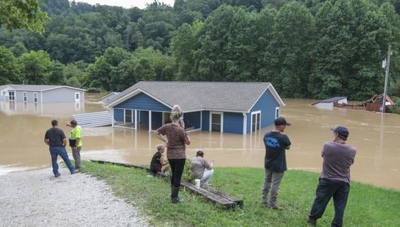 Una familia observa su casa sumergida por las inundaciones del North Fork del río Kentucky en Jackson, Kentucky, el 28 de julio de 2022. Foto: LEANDRO LOZADA / AFP